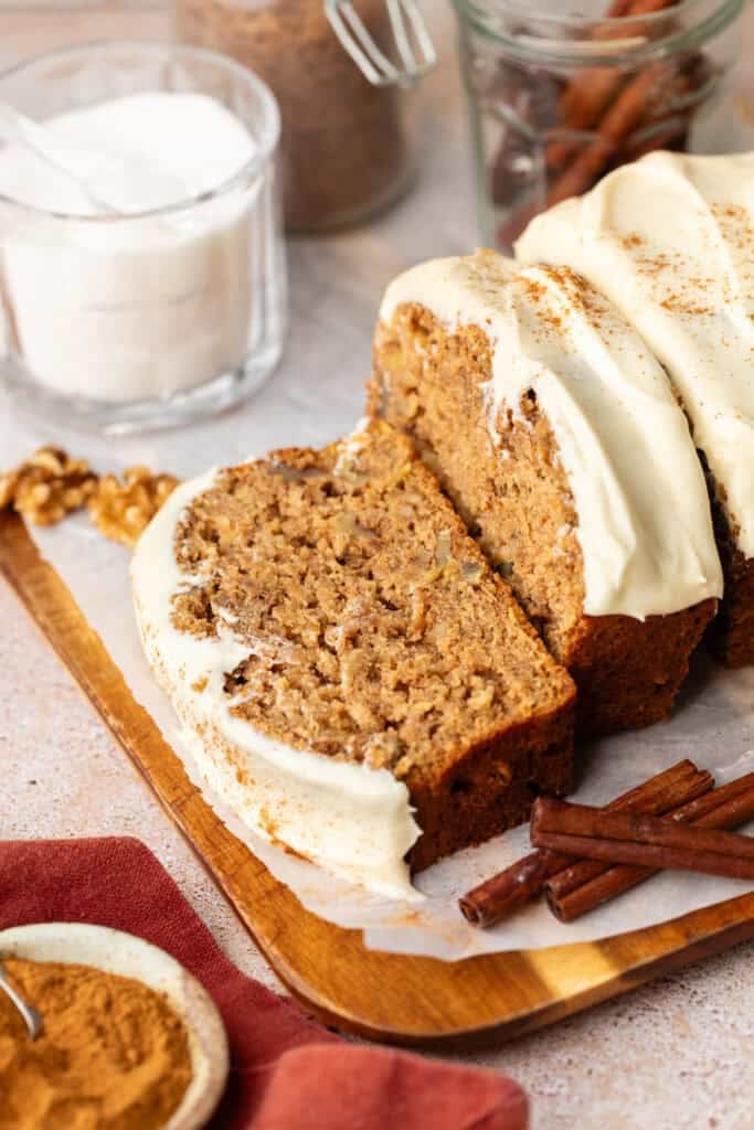 brown butter apple bread sliced and topped cream cheese frosting