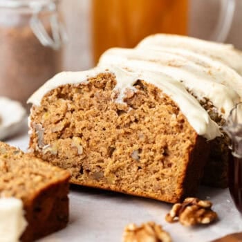 brown butter apple bread sliced and topped cream cheese frosting