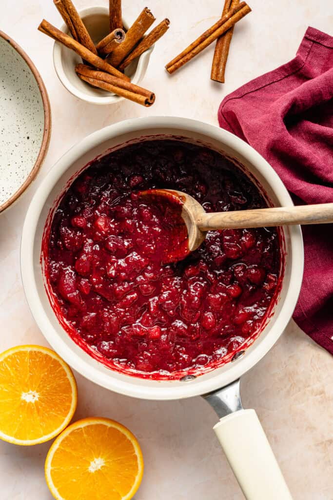 cranberry sauce in pot with wooden spoon