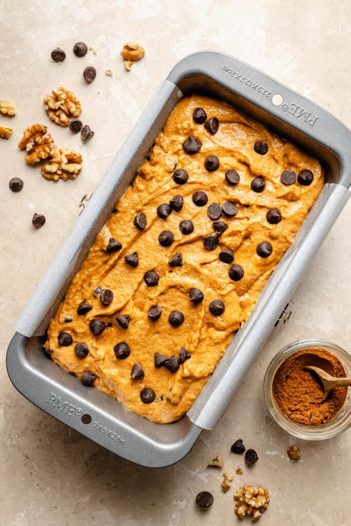pumpkin bread batter in loaf pan topped with chocolate chips