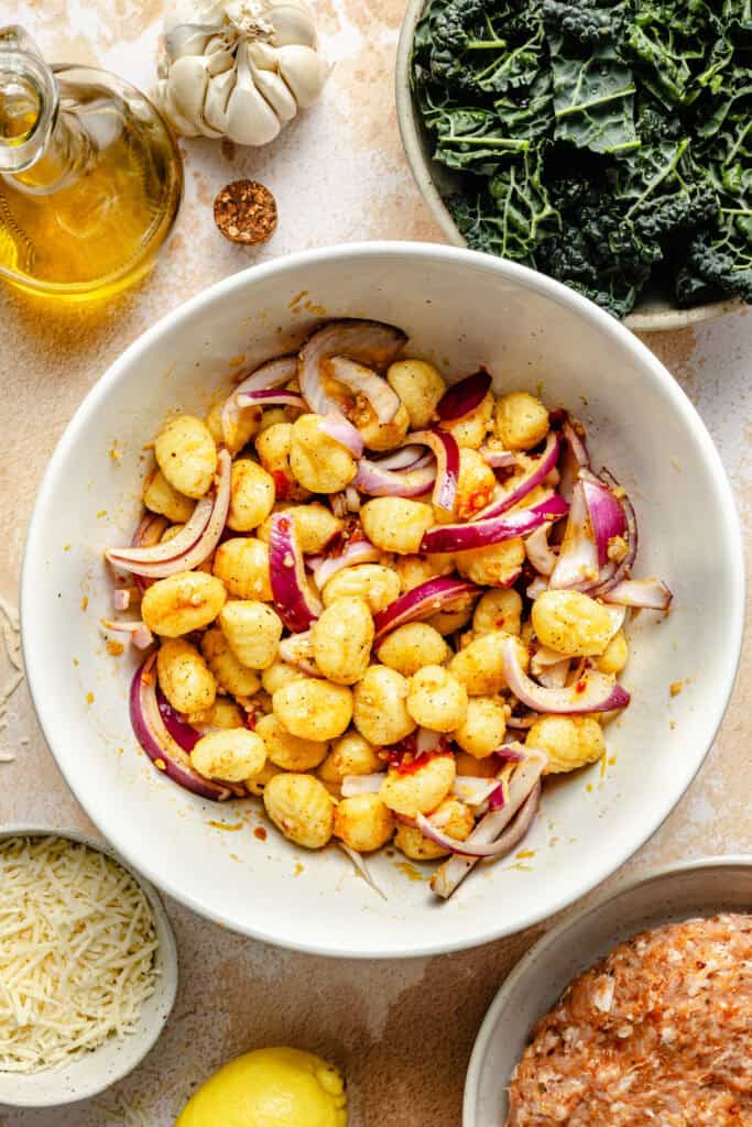 gnocchi and onions in mixing bowl