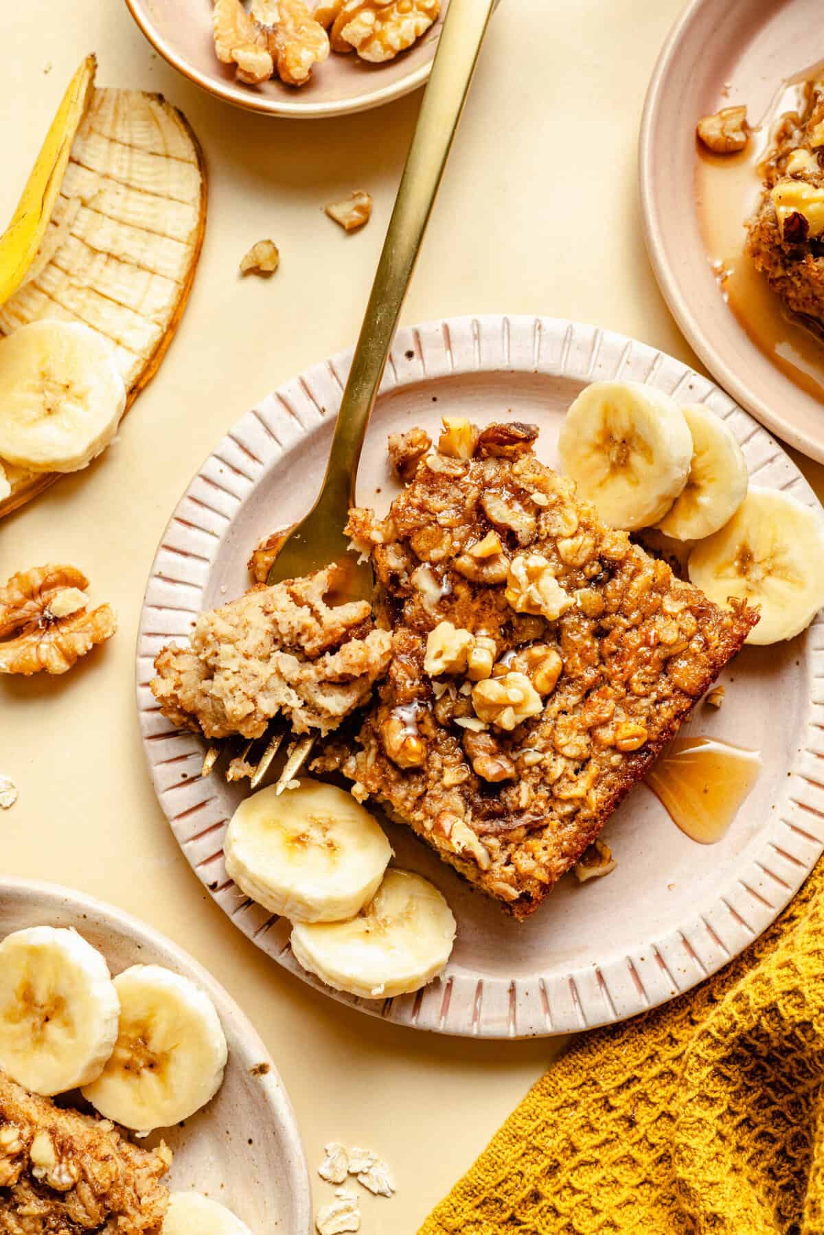 banana baked oatmeal on plate with fork and sliced bananas