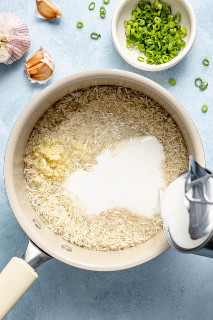 coconut milk being poured into pot