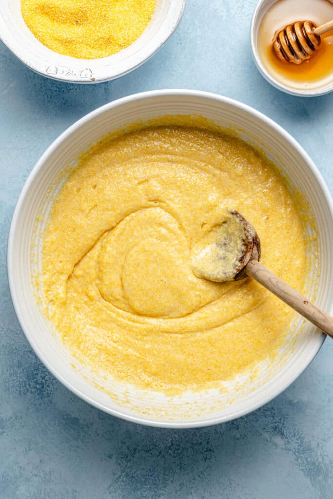 cornbread batter in mixing bowl with wooden spoon
