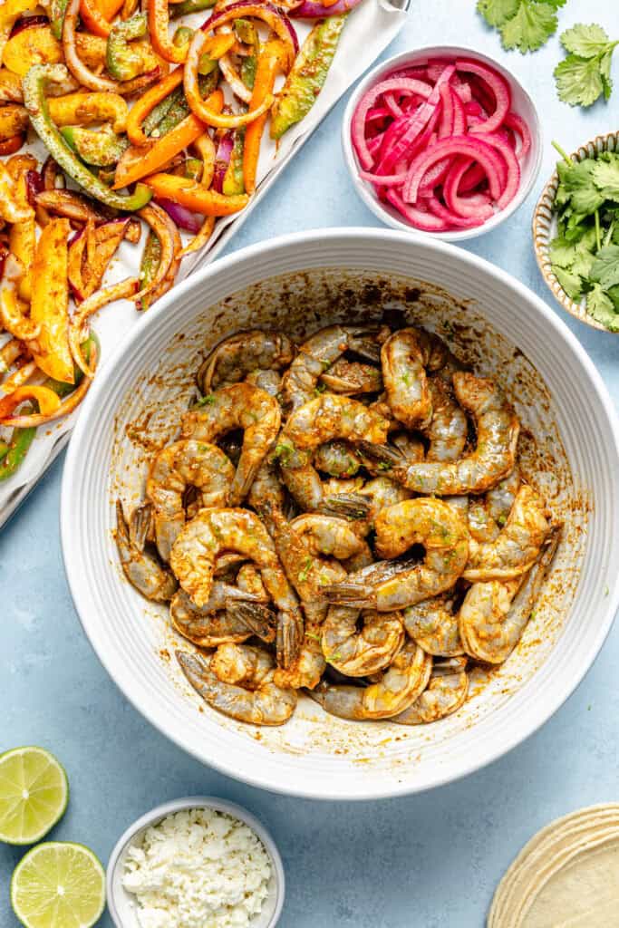 shrimp being seasoned in bowl