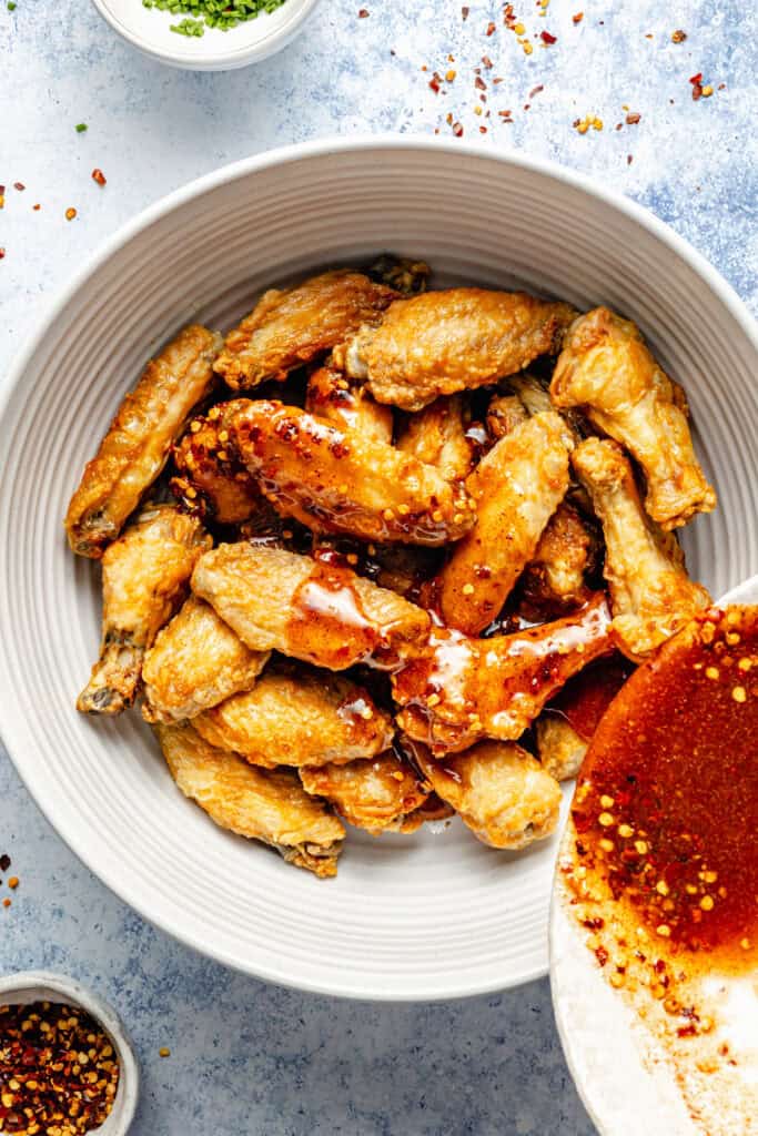hot honey sauce being poured over wings
