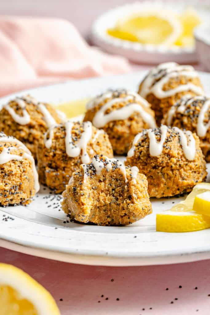 lemon poppy seed balls on plate with icing and lemon slices