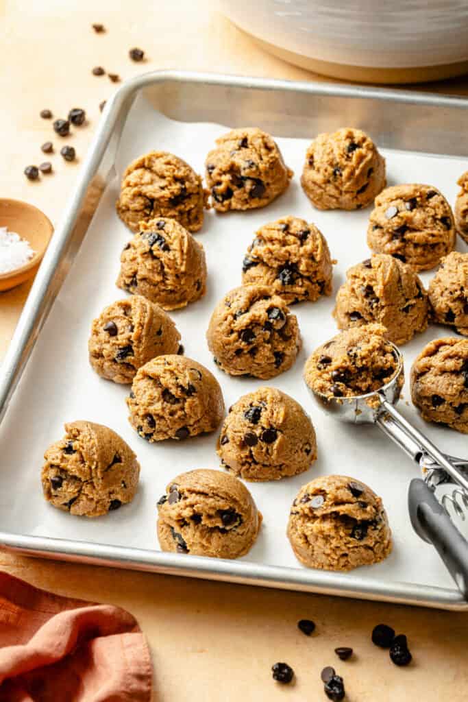 protein balls being scooped onto cookie sheet