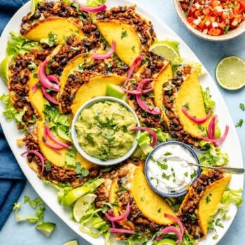 oven baked tacos on a platter with guacamole and greek yogurt