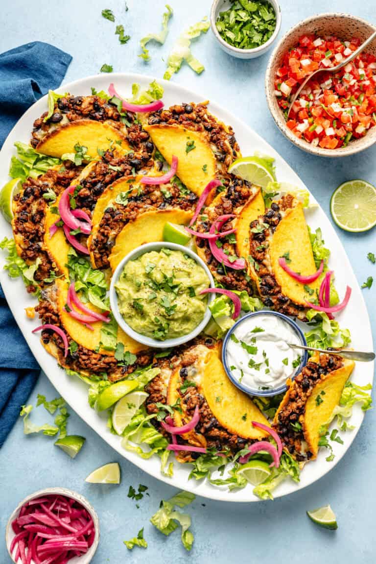 oven baked tacos on a platter with guacamole and greek yogurt