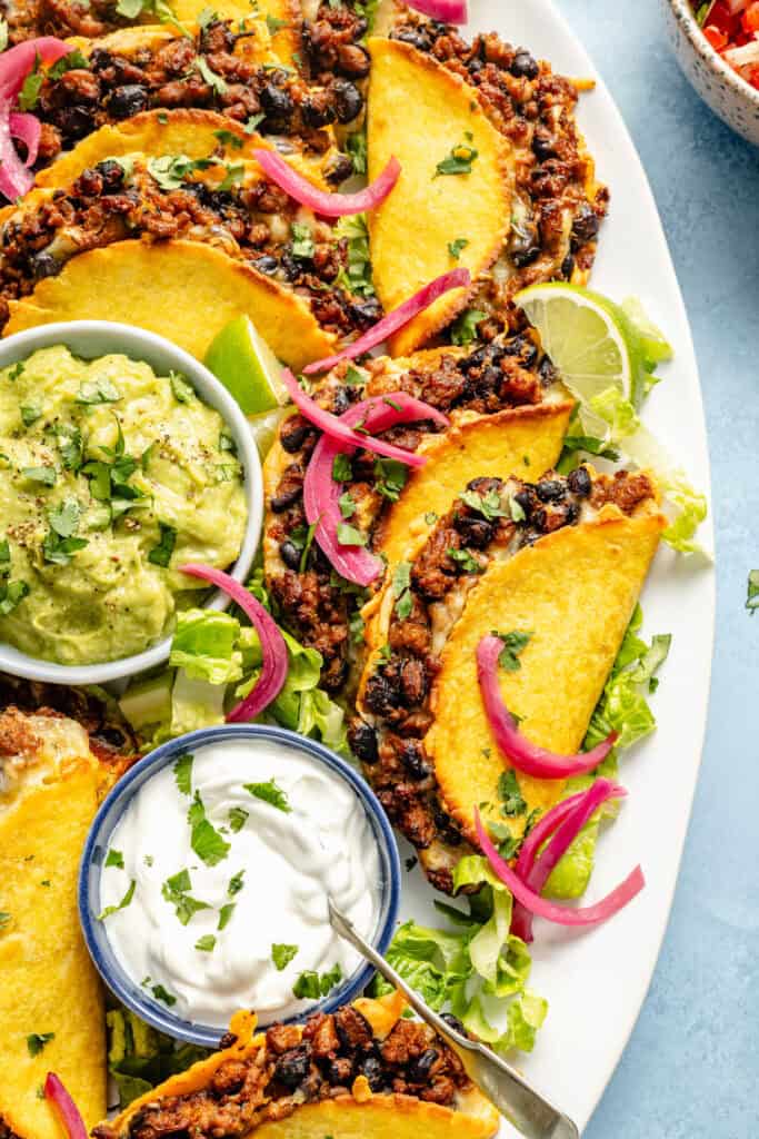 oven baked tacos on platter with toppings