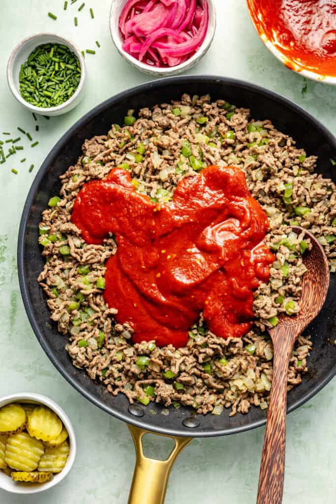 sloppy joe sauce being added to meat