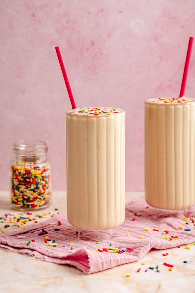 two glasses of cake batter protein shake with straw
