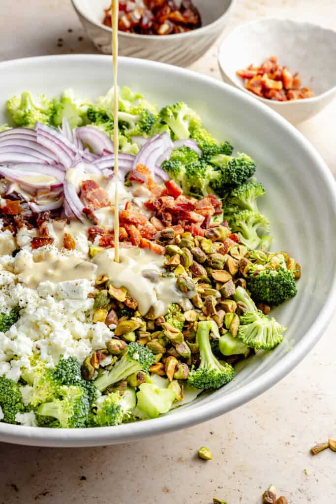 dressing being poured over salad
